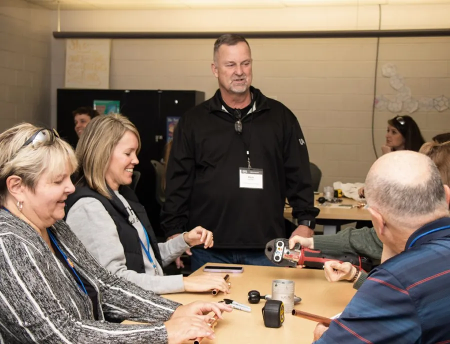 Educators working with trade tools at an I2W table session